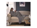 A woman in a grey hooded blanket on a beige sofa, holding a mug.