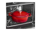 Red cast iron pot inside an oven