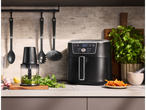 A SILVERCREST® XL Air Fryer on a kitchen counter with cooking utensils and fresh ingredients.