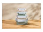 Stack of four collapsible food containers in green and beige on a wooden surface
