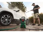 A man uses a Parkside pressure washer to clean his white SUV.