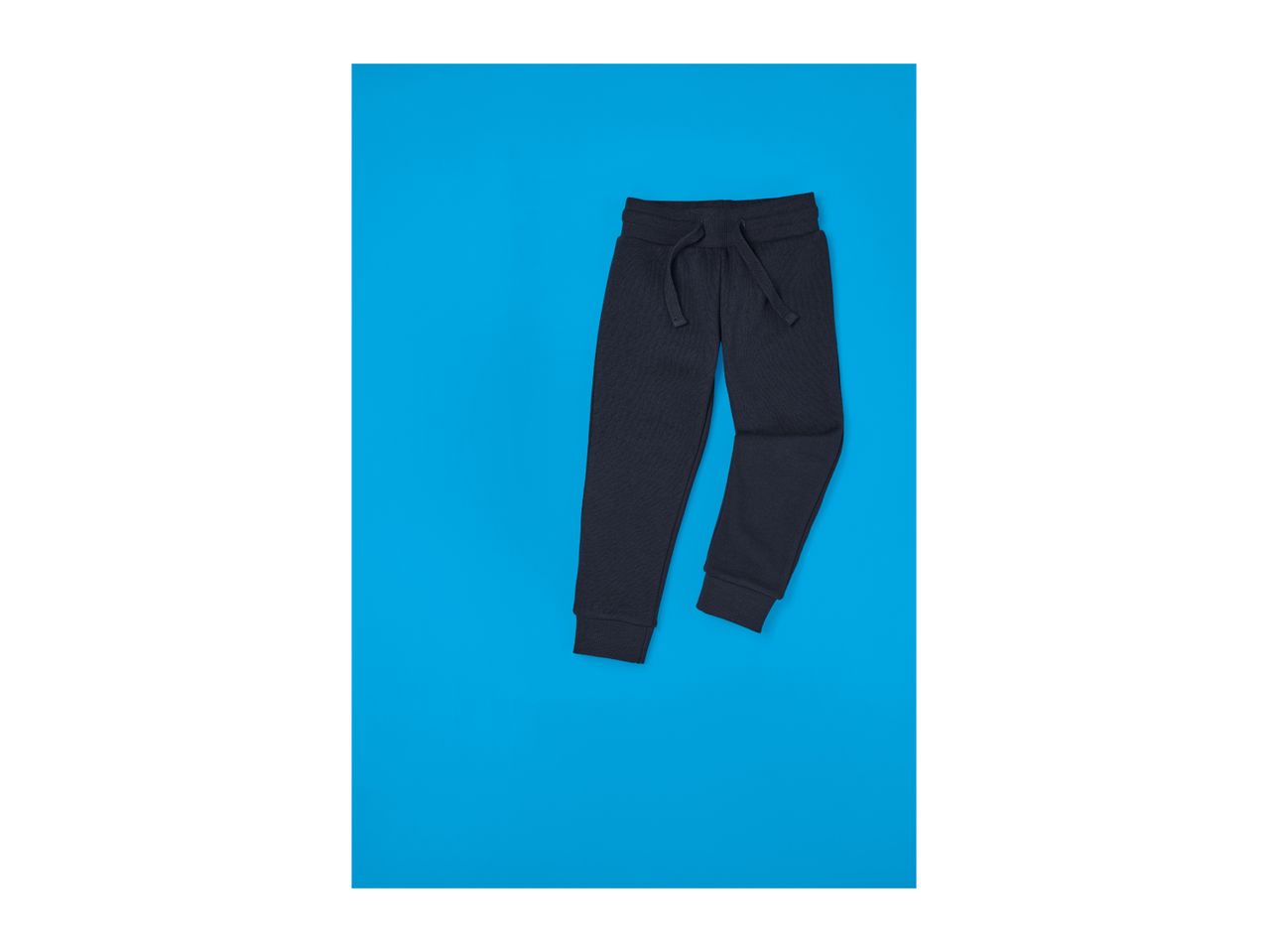 Dark blue children's sweatpants with a drawstring waist on a blue background.