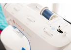 Máquina de costura Singer M3205 com linha azul no carretel.
