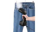 Mão a vaporizar jeans com uma escova a vapor Silvercrest®.