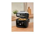 Multi-cooker with open lid filled with french fries on a wooden kitchen counter