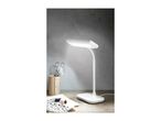 White desk lamp illuminating a workspace with sewing supplies.