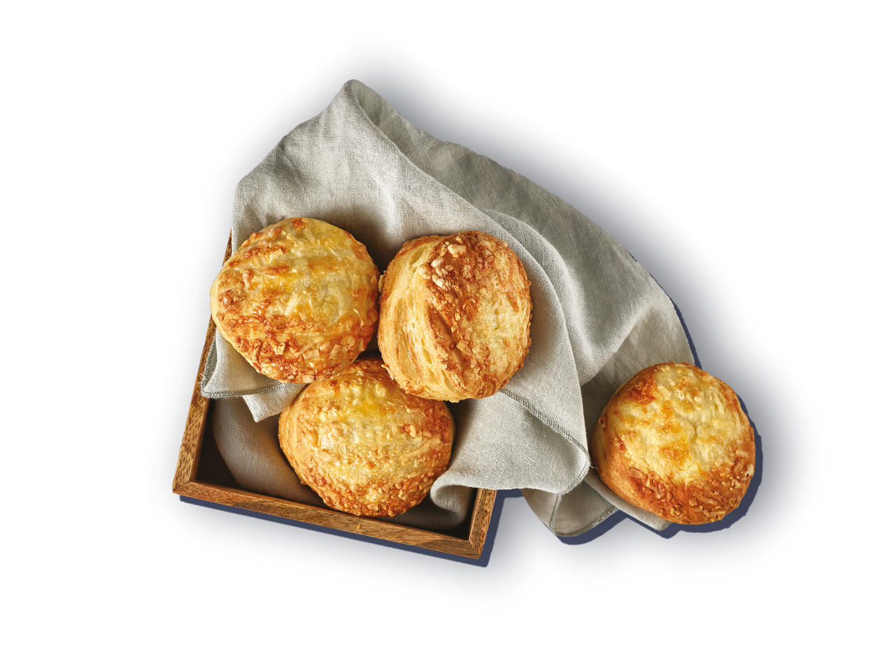 Četiri zlatno-smeđe peciva sa sirom u drvenoj košari s bijelom platnenom salvetom.