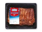 En pakke hotte spareribs med etiket, der viser pakkedato, holdbarhedsdato, nettovægt og pris.