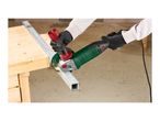 Person using an angle grinder to cut a metal square tube on a wooden workbench.