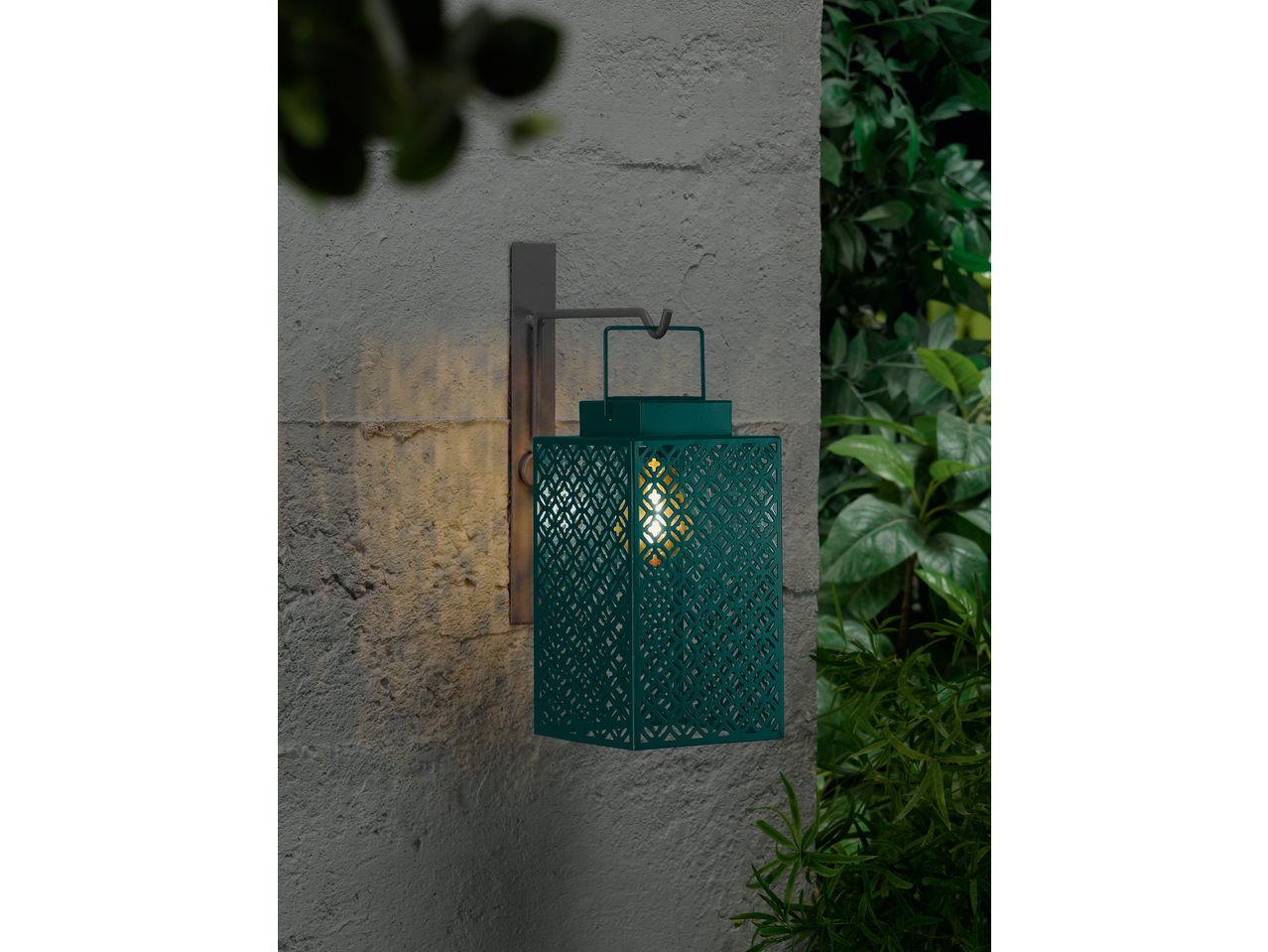 LIVARNO home LED Solar Lantern, teal, with decorative cut-outs, mounted on a textured wall.