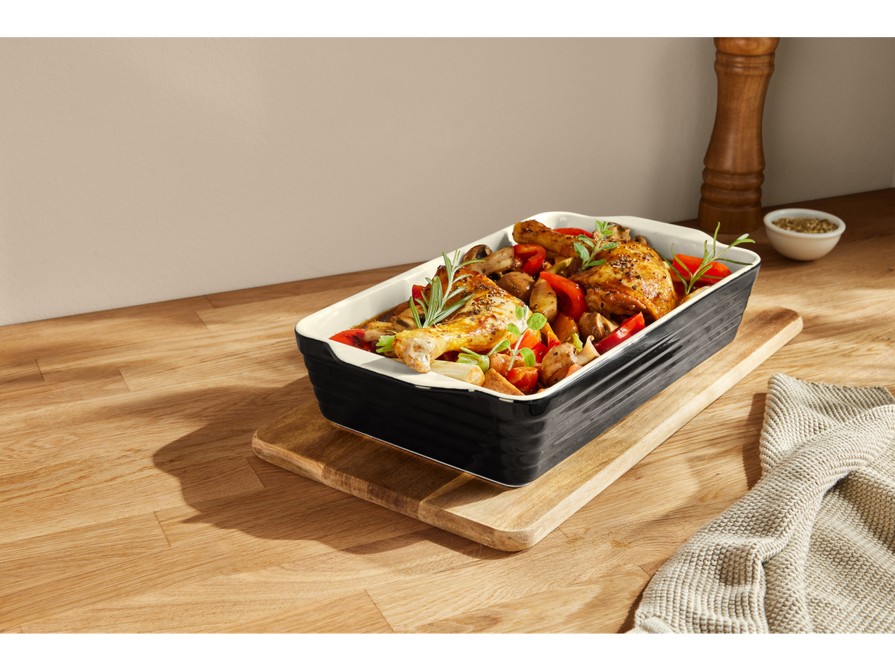 Silvercrest® ahjuvorm röstitud kana ja köögiviljadega puidust laual.