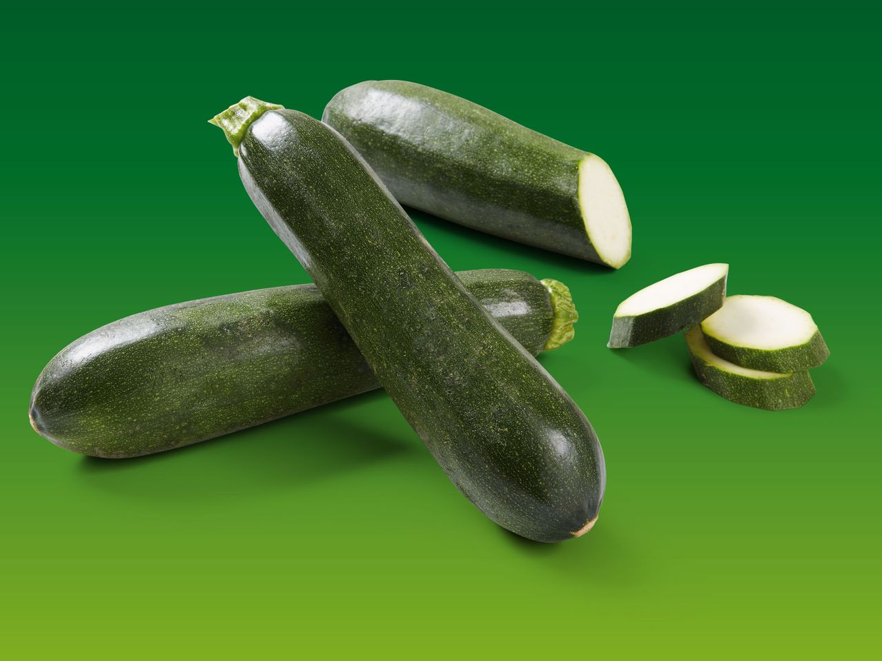 Grüne Zucchini, ganz und in Scheiben geschnitten.
