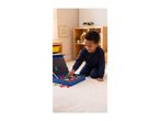 A young boy playing with a magnetic letter and number learning board on a rug.