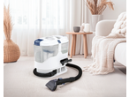 Carpet cleaner on a light rug in a bright living room with natural decor.