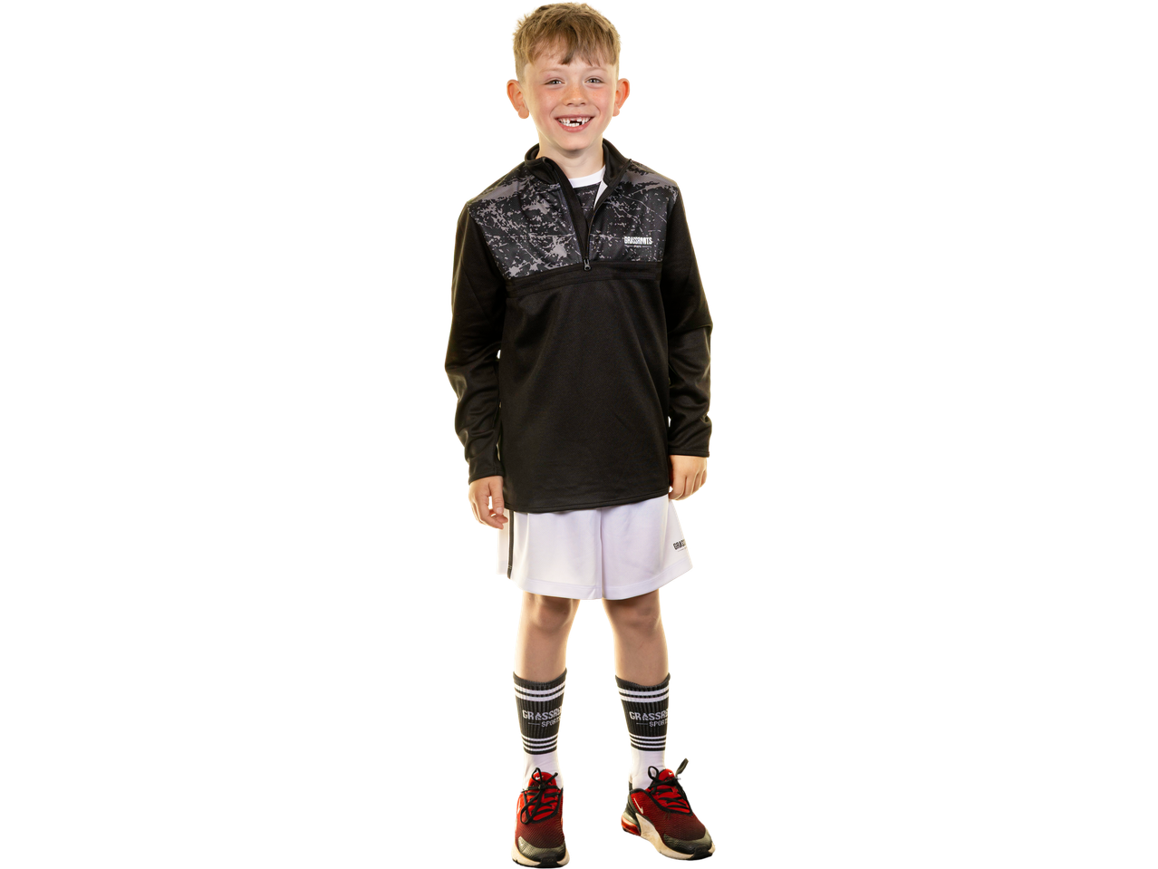 Boy in black training top and white training shorts with 'GRASSROOTS SPORTS' logo.