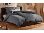 Modern bedroom with a bed featuring dark grey geometric pattern duvet cover and pillows.