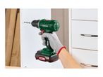 A person drilling into a white cabinet with a cordless drill, wearing grey work gloves.