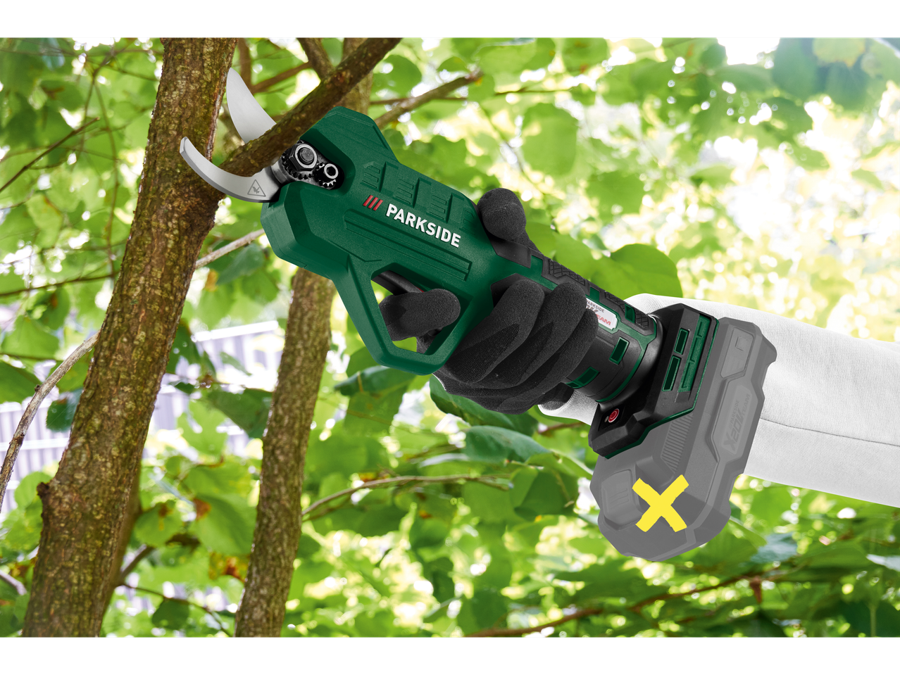 Persoană care folosește foarfeca de grădină cu acumulator PARKSIDE® pentru a tăia o creangă.