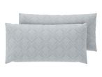 Two light green patterned pillows with a leaf design, one slightly behind the other.