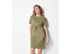 O femeie într-o rochie-tricou verde măslin, cu cordon în talie.