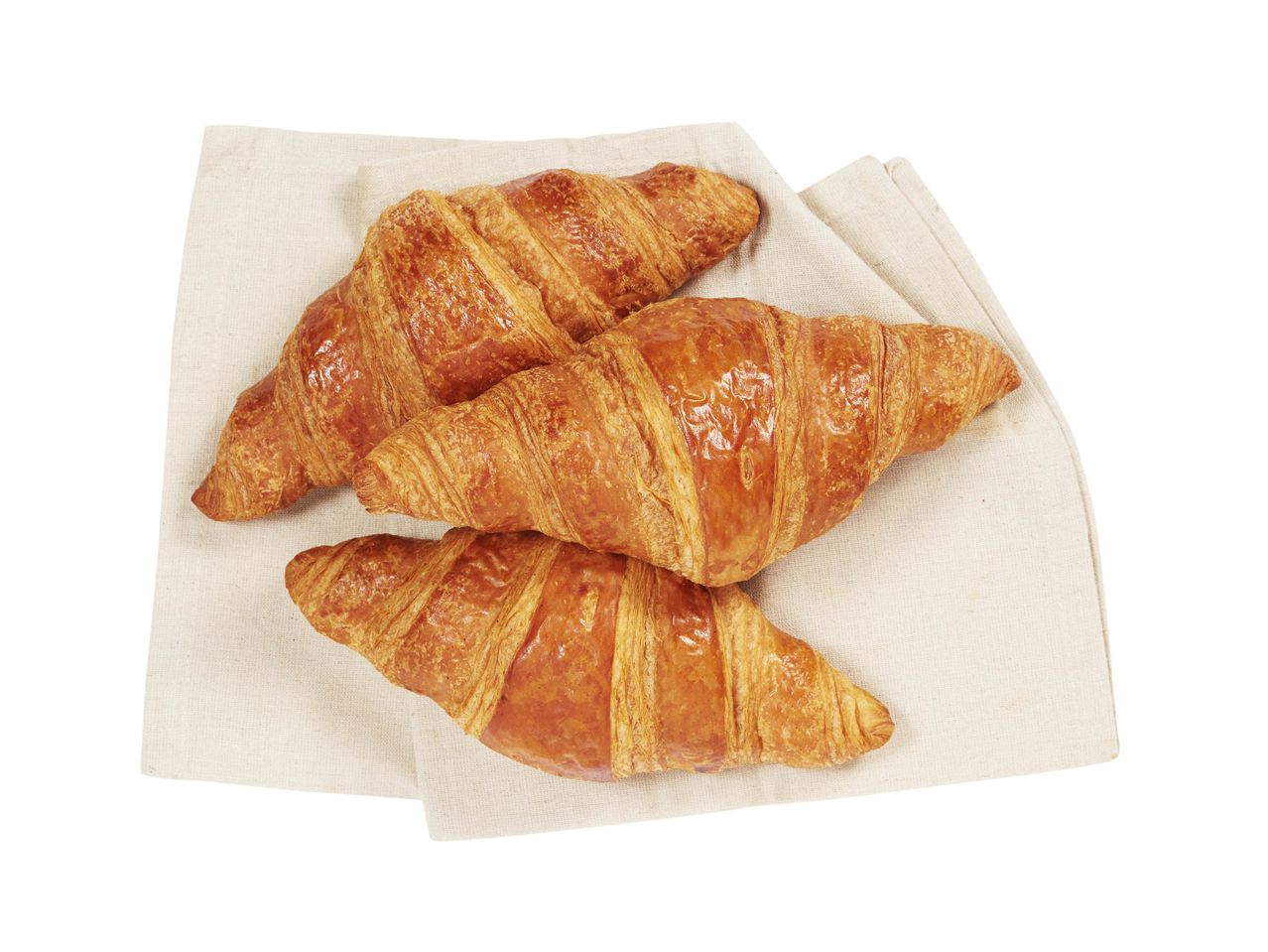 Quatre croissants dorés sur une serviette.
