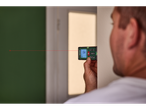 Parkside® Laser Distance Measurer in use, measuring a room with a red laser line.