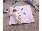 A baby lies on a Baby Milestone Blanket with growth chart, surrounded by toys.