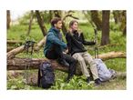 Two hikers in outdoor clothing and shoes, with backpacks and walking poles, sitting on a log.