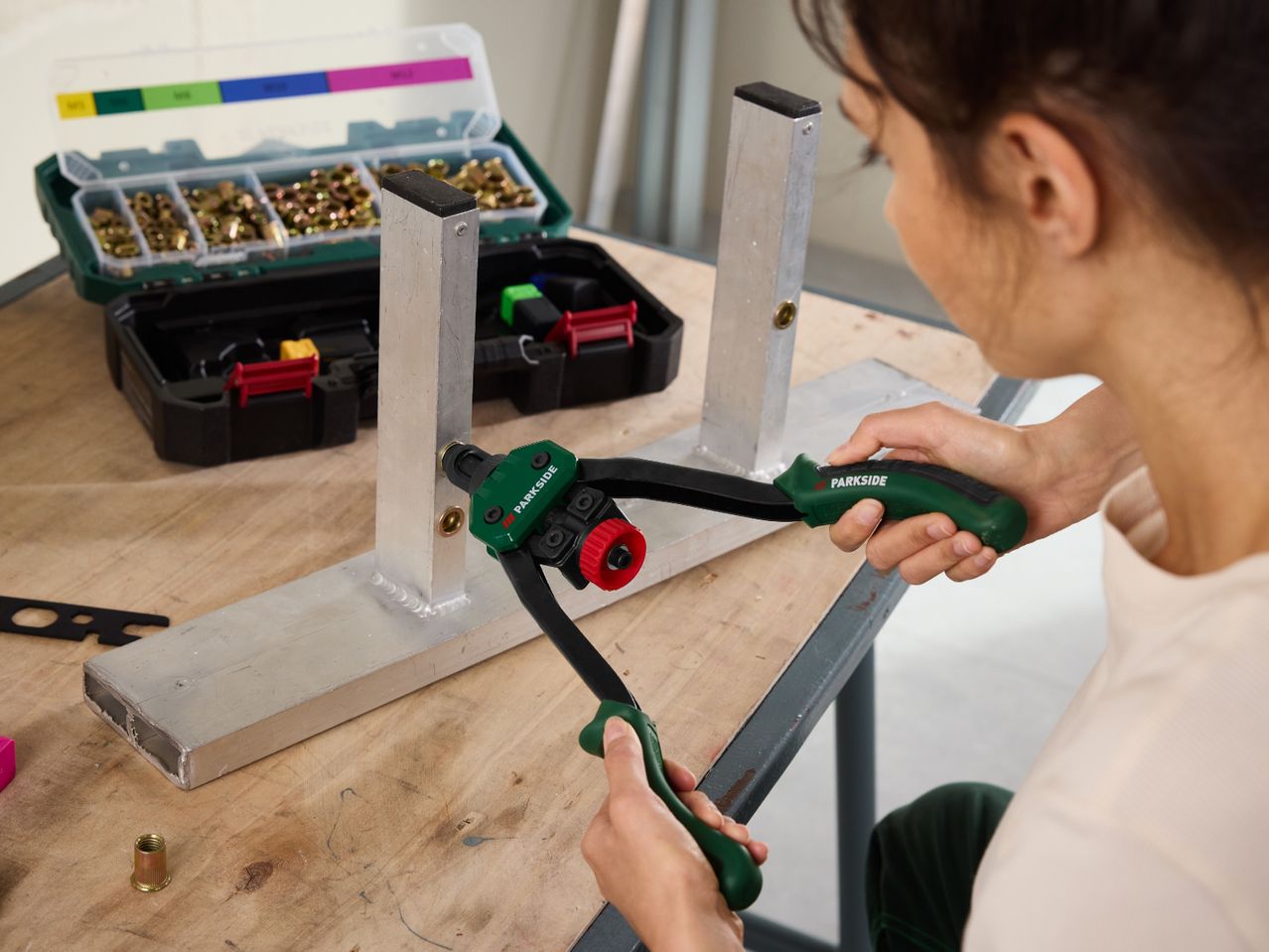 A person uses a Parkside rivet nut plier to attach a rivet nut to an aluminum profile.