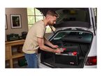 Man placing car cleaning products in a trunk organizer in a car trunk.