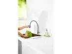 O persoană spală salată într-o chiuvetă cu o baterie înaltă.