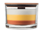 Eine Kerze in einem Glasgefäß mit drei Schichten: weiß, gelb und orange, mit einem Holzdeckel.