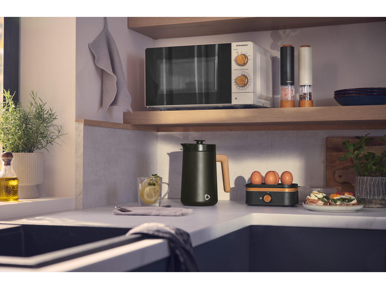 SILVERCREST® 700W Microwave in a modern kitchen with other kitchenware and food.