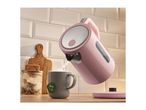 Pink electric kettle pouring hot water into a grey mug with a tea bag, on a wooden counter.