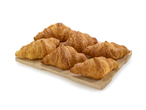 Croissants dorés disposés sur une planche en bois.