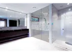 Banheiro moderno com um elegante box de vidro e pia de mármore preto.
