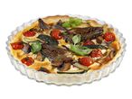 Zöldséges quiche üveg sütőformában, fehér háttér előtt.