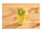 Yellow travel mug with a handle and straw on a wooden table