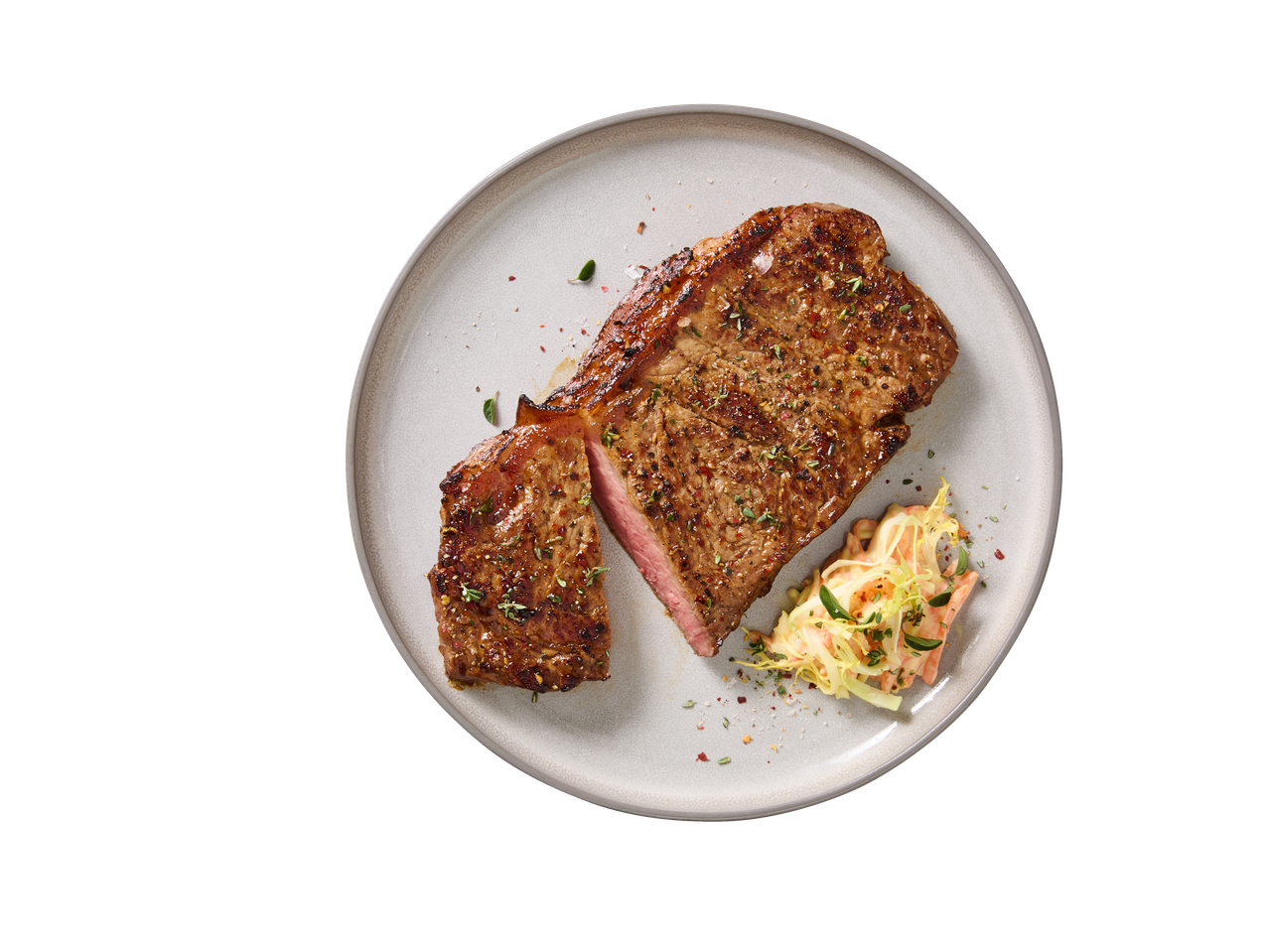Bife de Angus Rib Eye fresco DELUXE com salada de repolho num prato.
