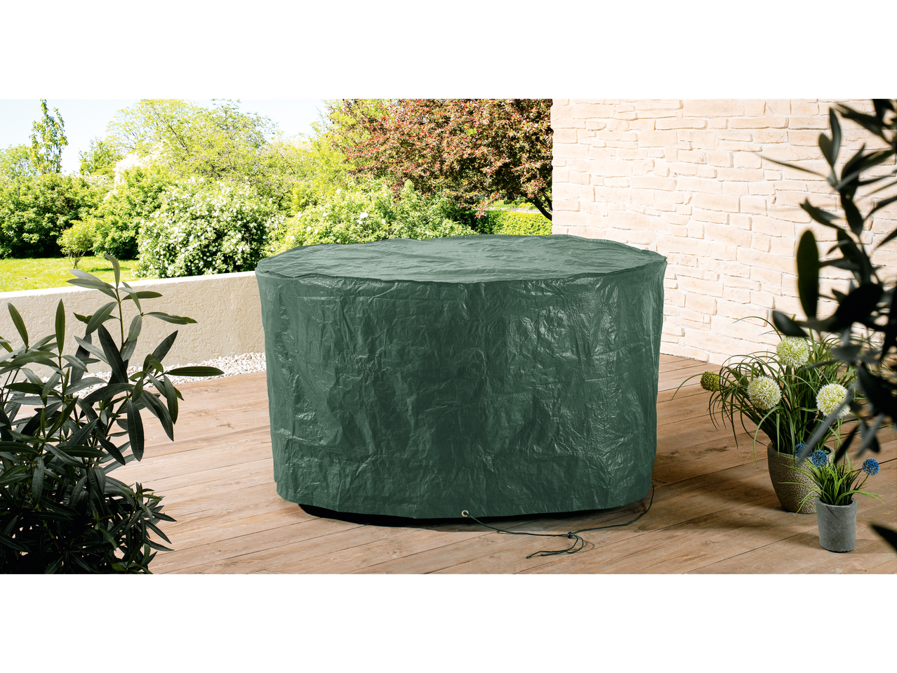 Husă verde pentru mobilier de grădină pe o terasă din lemn cu plante