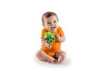 Happy baby in orange bodysuit holding a green frog-shaped rattle.