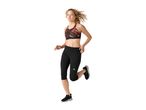 Woman running in a black and red patterned sports bra and black capri leggings.