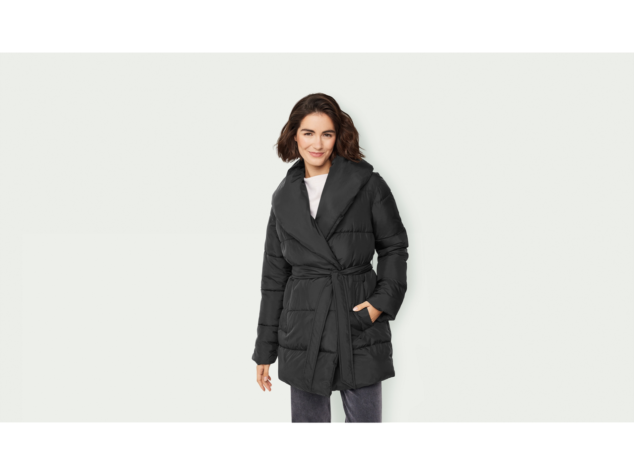 Naine kannab musta esmara® Kappa tepitud jopet, vöö ja laia kraega.