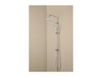 Chrome shower system with a round overhead shower and a handheld shower in a corner.