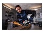 Man in safety glasses and gloves using a cordless angle grinder, creating sparks on a metal surface.
