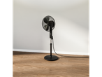 Ventilador de chão preto em piso de madeira.