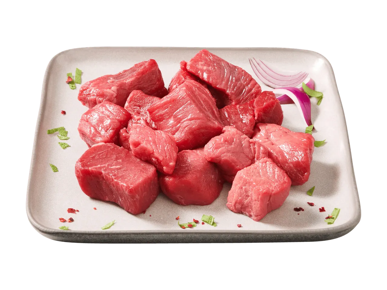 Frische Rinderwürfel auf einer Platte mit Zwiebeln und Kräutern.