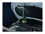 Cordless LED work light hanging from a car hood, illuminating the engine bay