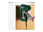 Electric stapler in use, fastening a cabinet back panel.