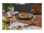 Cast iron skillet with roasted potatoes, walnuts, and pomegranate on an outdoor table.